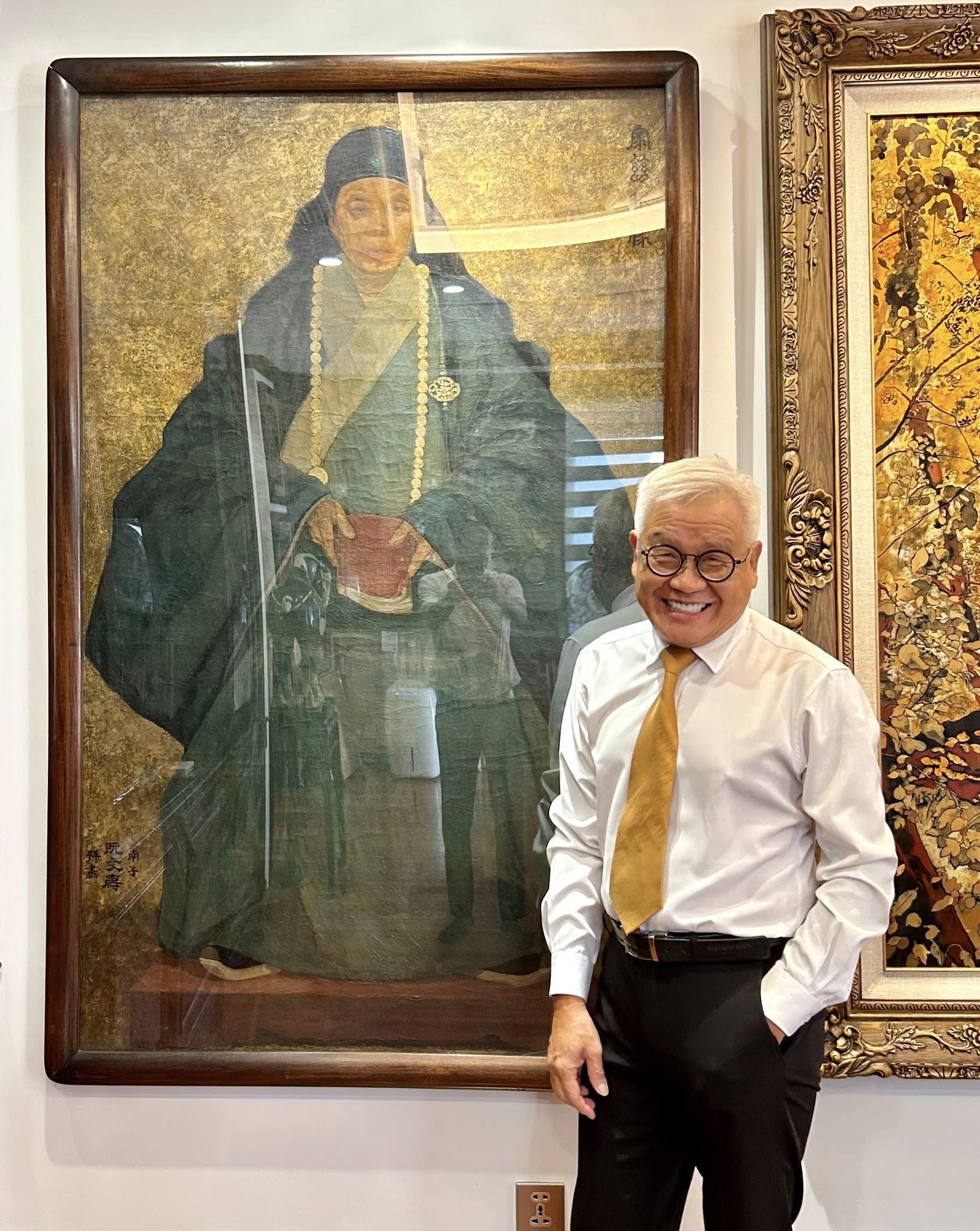 Nhà nghiên cứu mỹ thuật Ngô Kim Khôi đứng cạnh tác phẩm "Chân dung mẹ tôi" của danh hoạ Nam Sơn